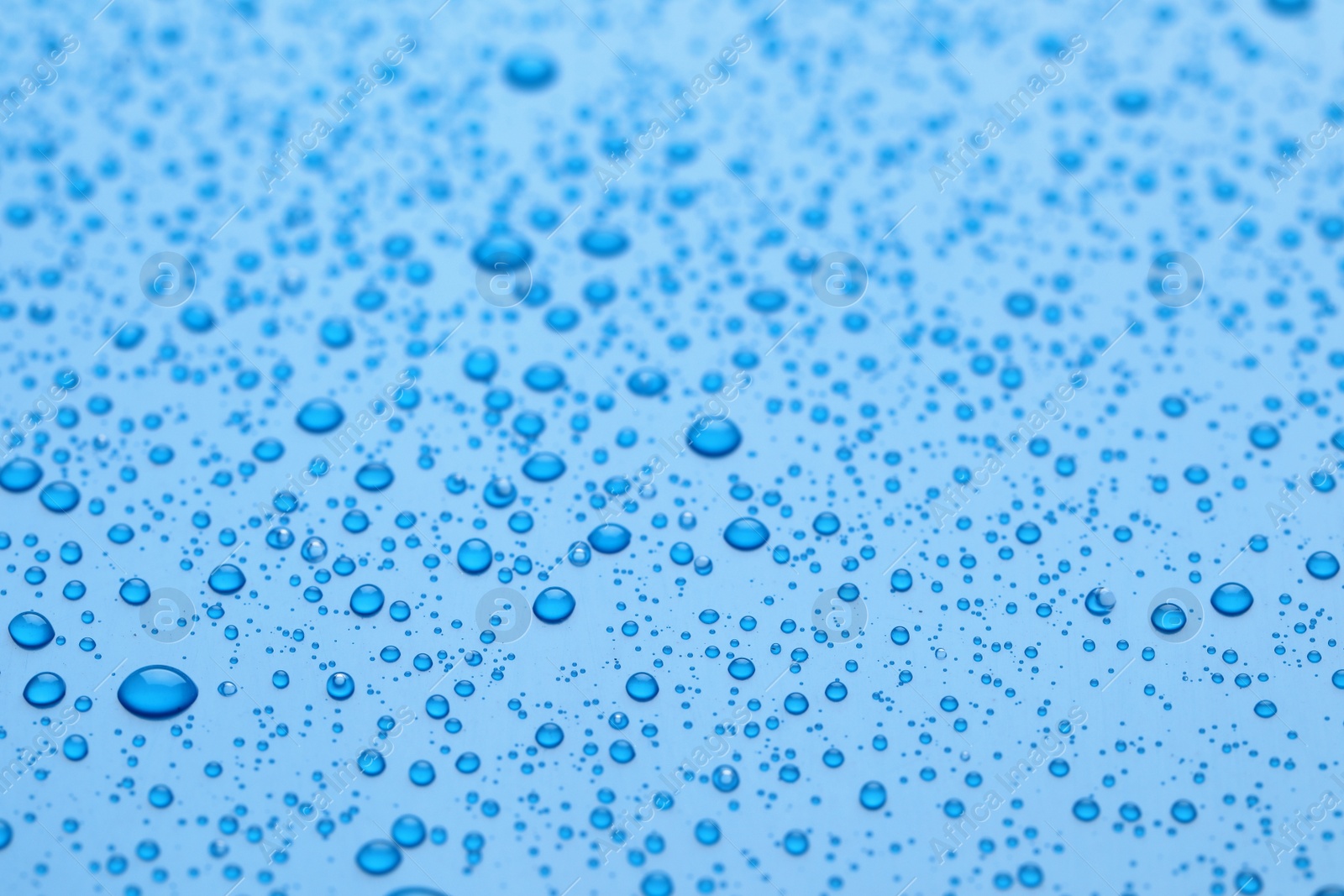 Photo of Water drops on blue background, closeup view