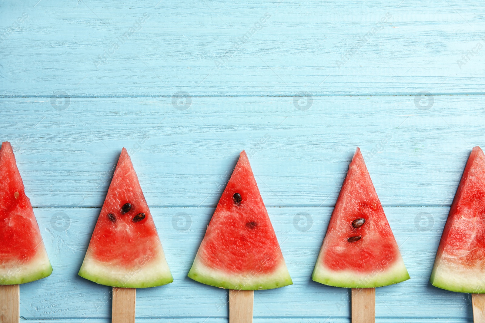 Photo of Flat lay composition with watermelon popsicles on wooden background