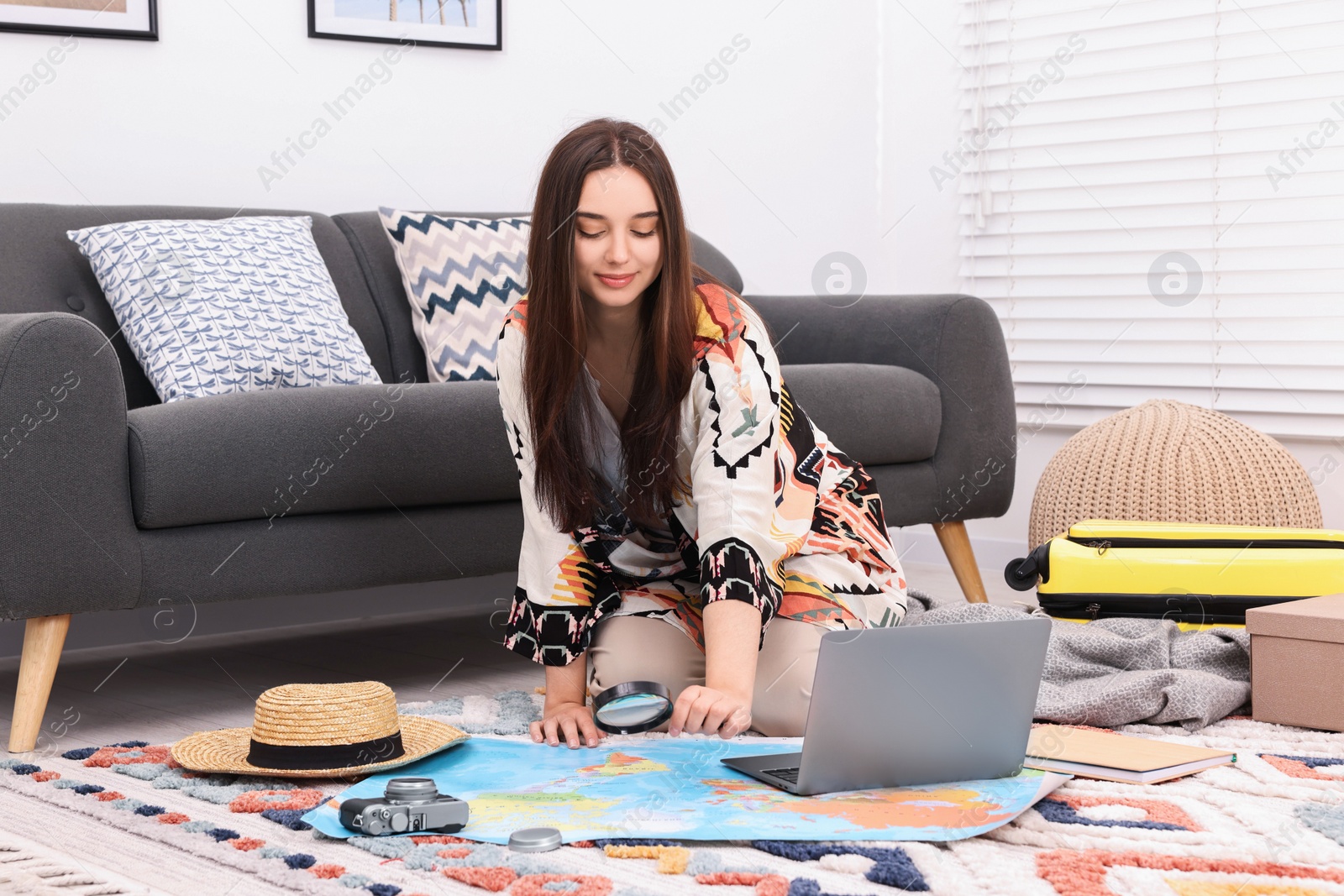 Photo of Travel blogger with magnifying glass and map planning trip at home