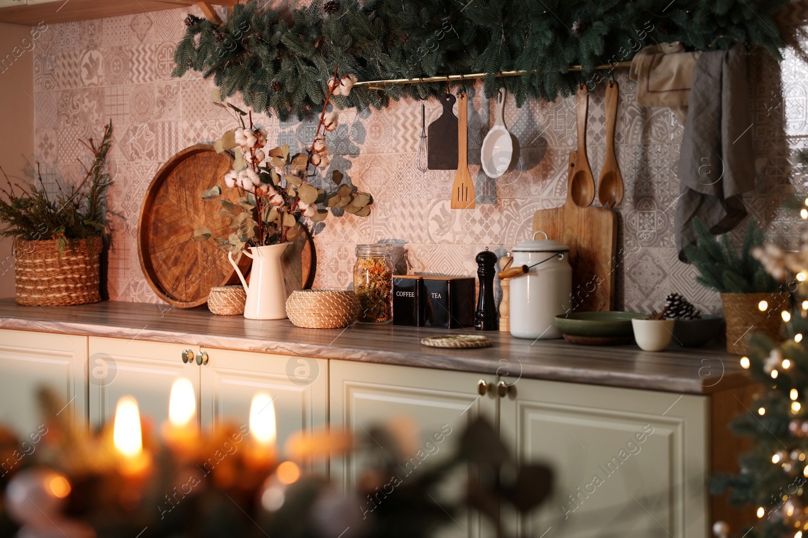 Photo of Stylish kitchen with festive decor and Christmas garland. Interior design