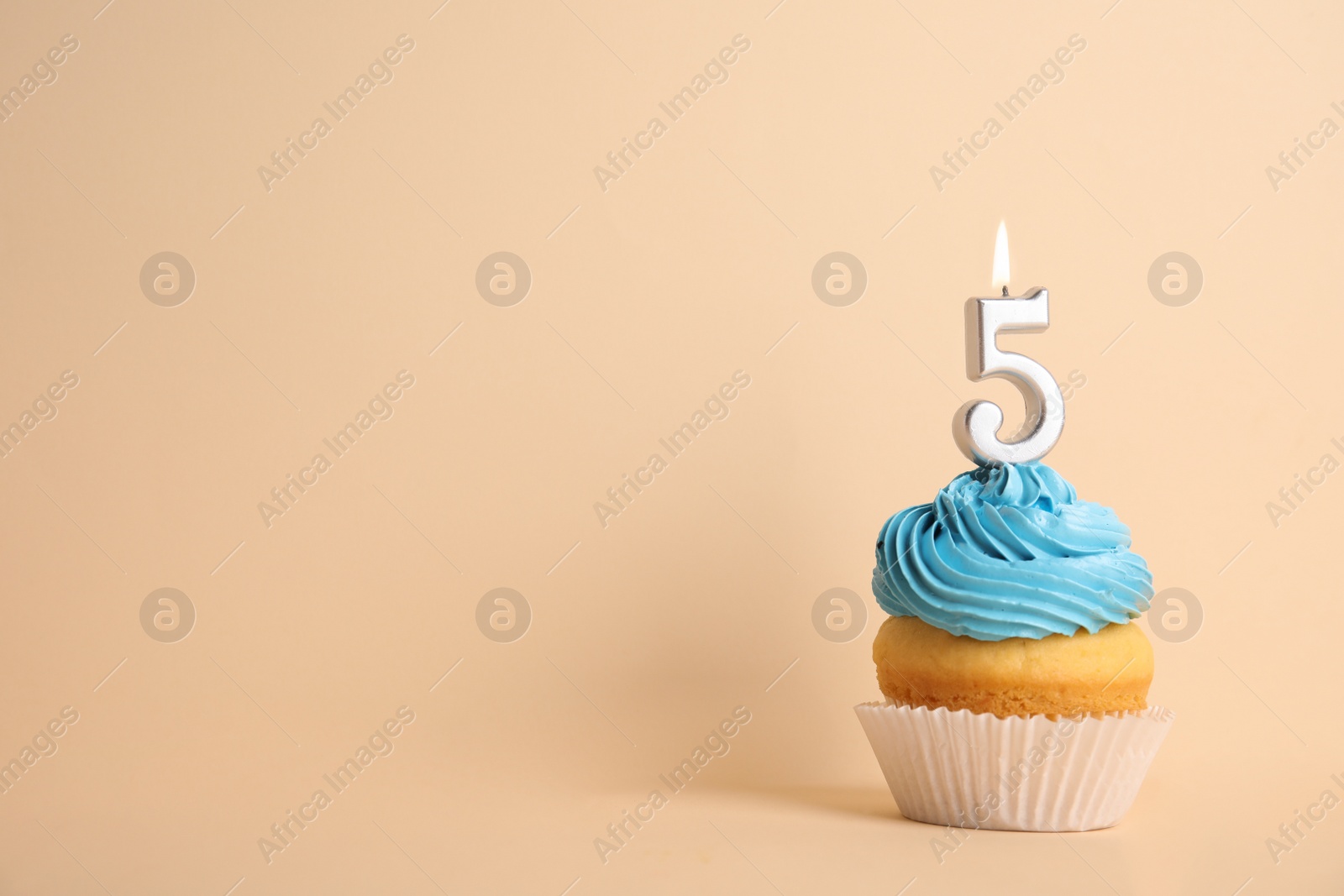 Photo of Birthday cupcake with number five candle on beige background, space for text