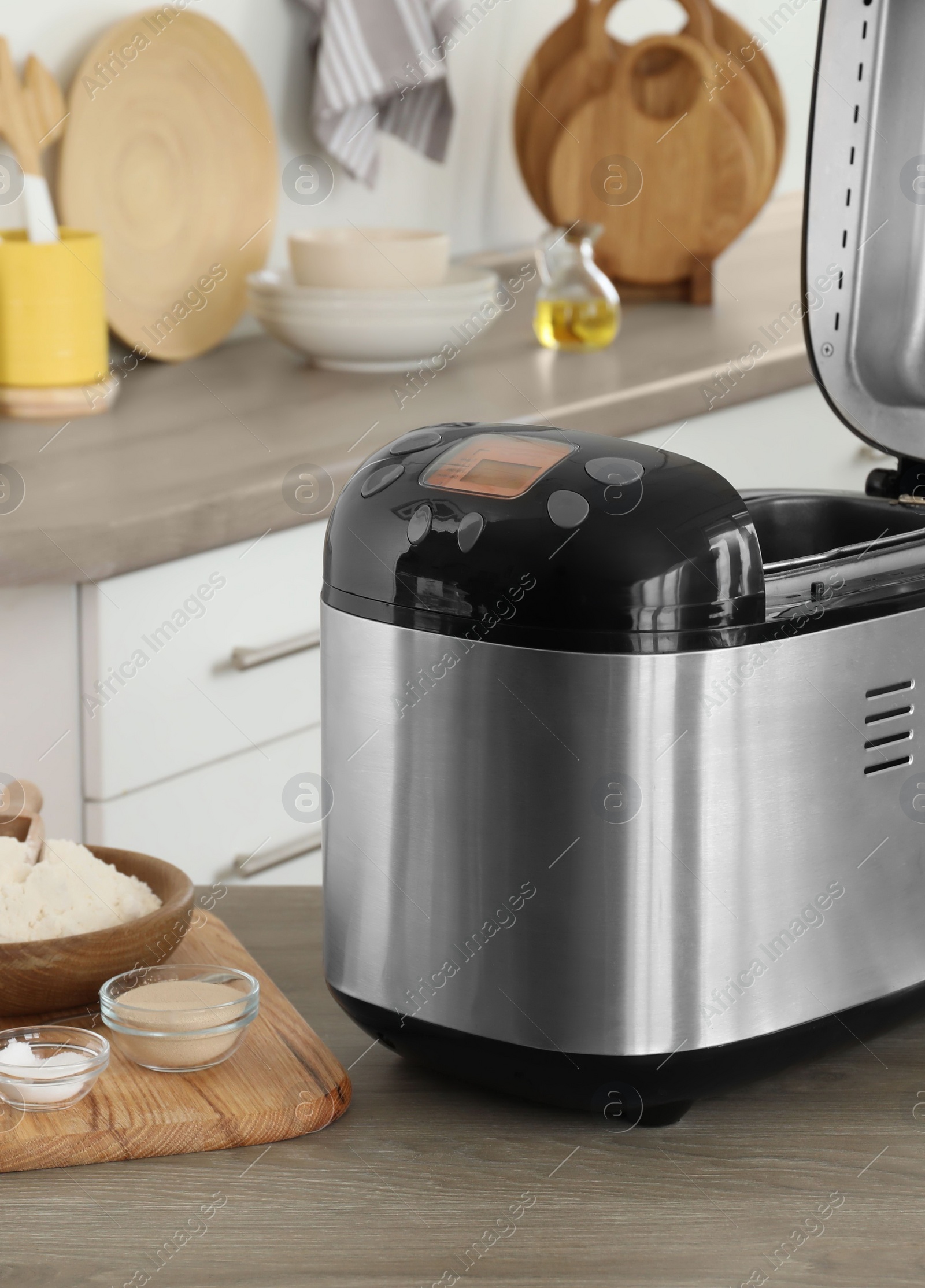 Photo of Breadmaker and products on wooden table in kitchen