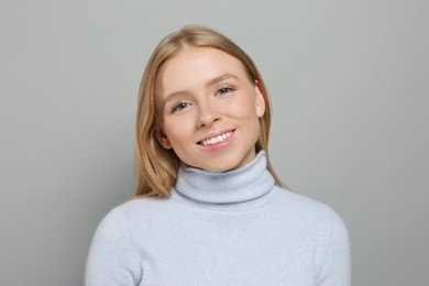 Photo of Portrait of beautiful young woman on grey background