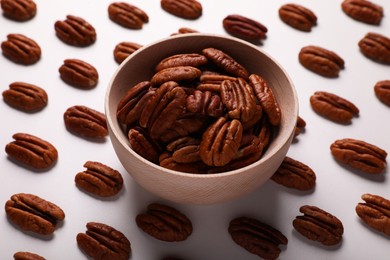 Photo of Delicious fresh pecan nuts and bowl on white background