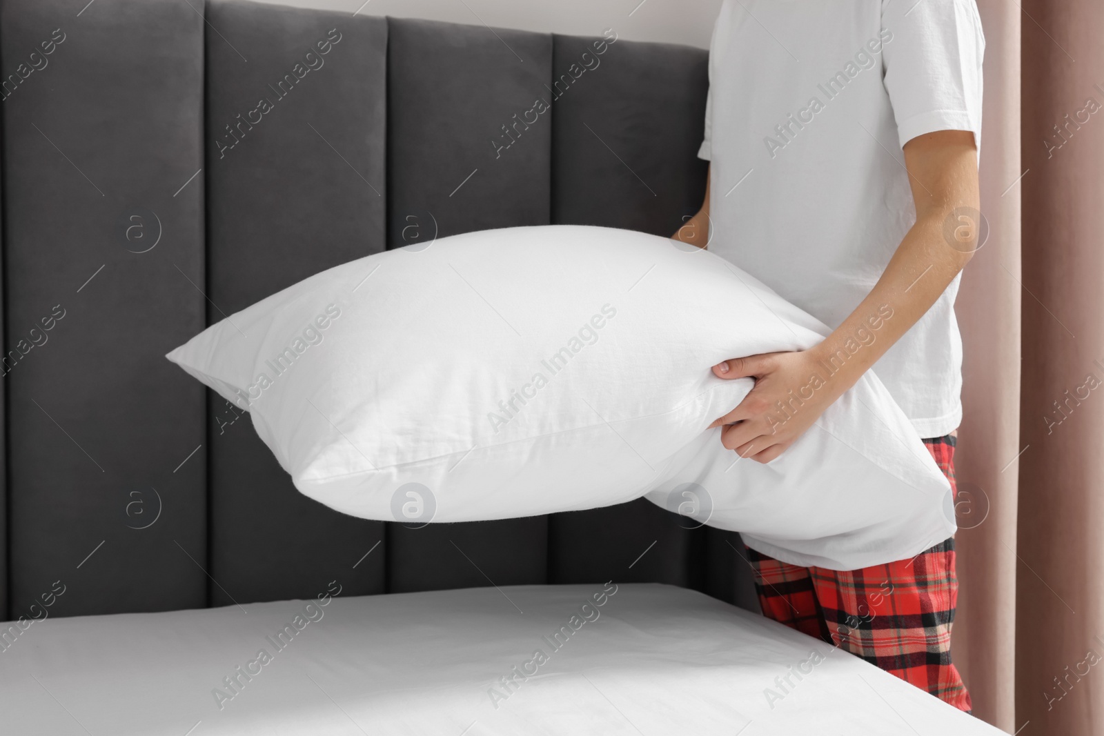 Photo of Boy changing bed linens in bedroom, closeup