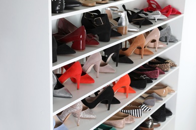 Shelving unit with different shoes. Element of dressing room interior