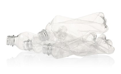 Photo of Crumpled disposable plastic bottles isolated on white