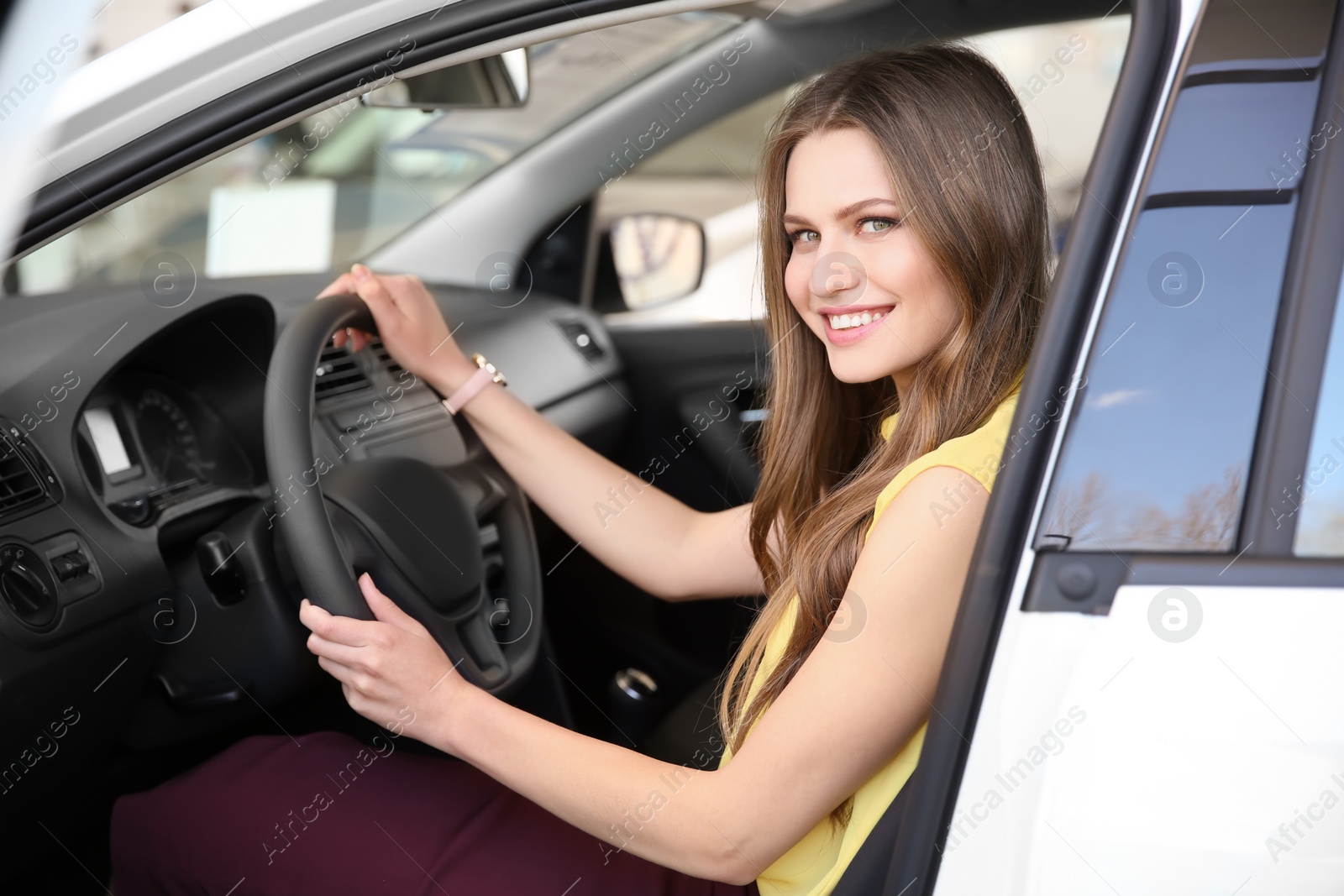 Photo of Young woman sitting on driver's seat of car