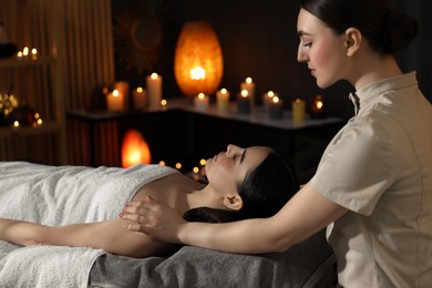 Photo of Spa therapy. Beautiful young woman lying on table during massage in salon