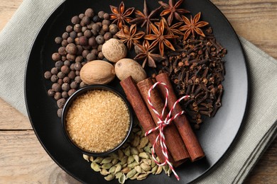 Dishware with different spices on wooden table, top view