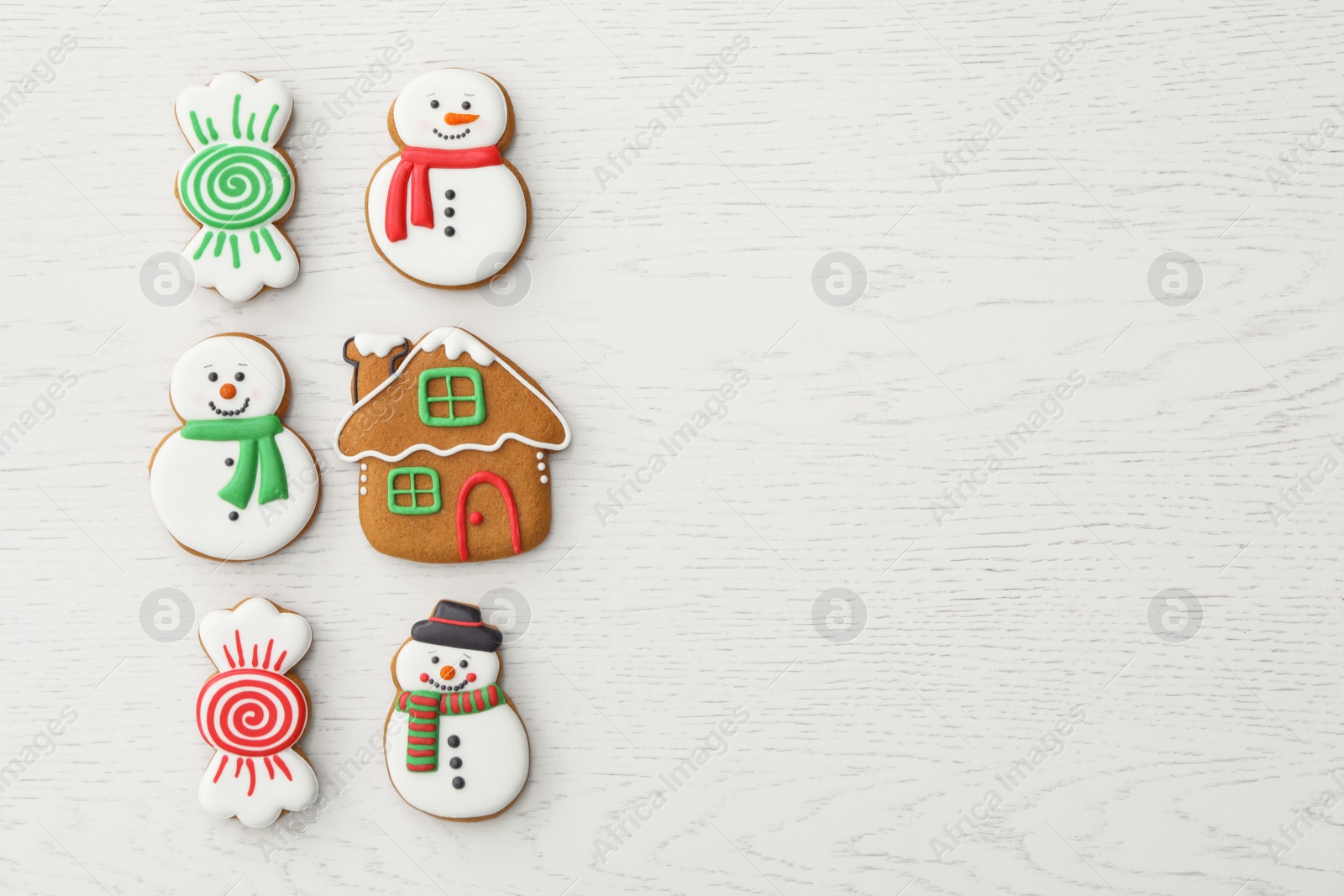 Photo of Different Christmas gingerbread cookies on white wooden table, flat lay. Space for text