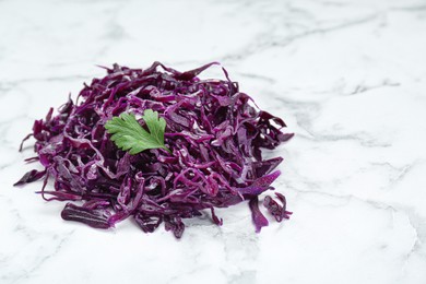 Photo of Tasty red cabbage sauerkraut with parsley on white marble table. Space for text