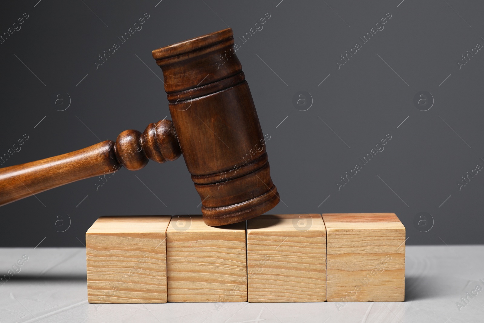 Photo of Law. Blank wooden cubes and gavel on light table against gray background