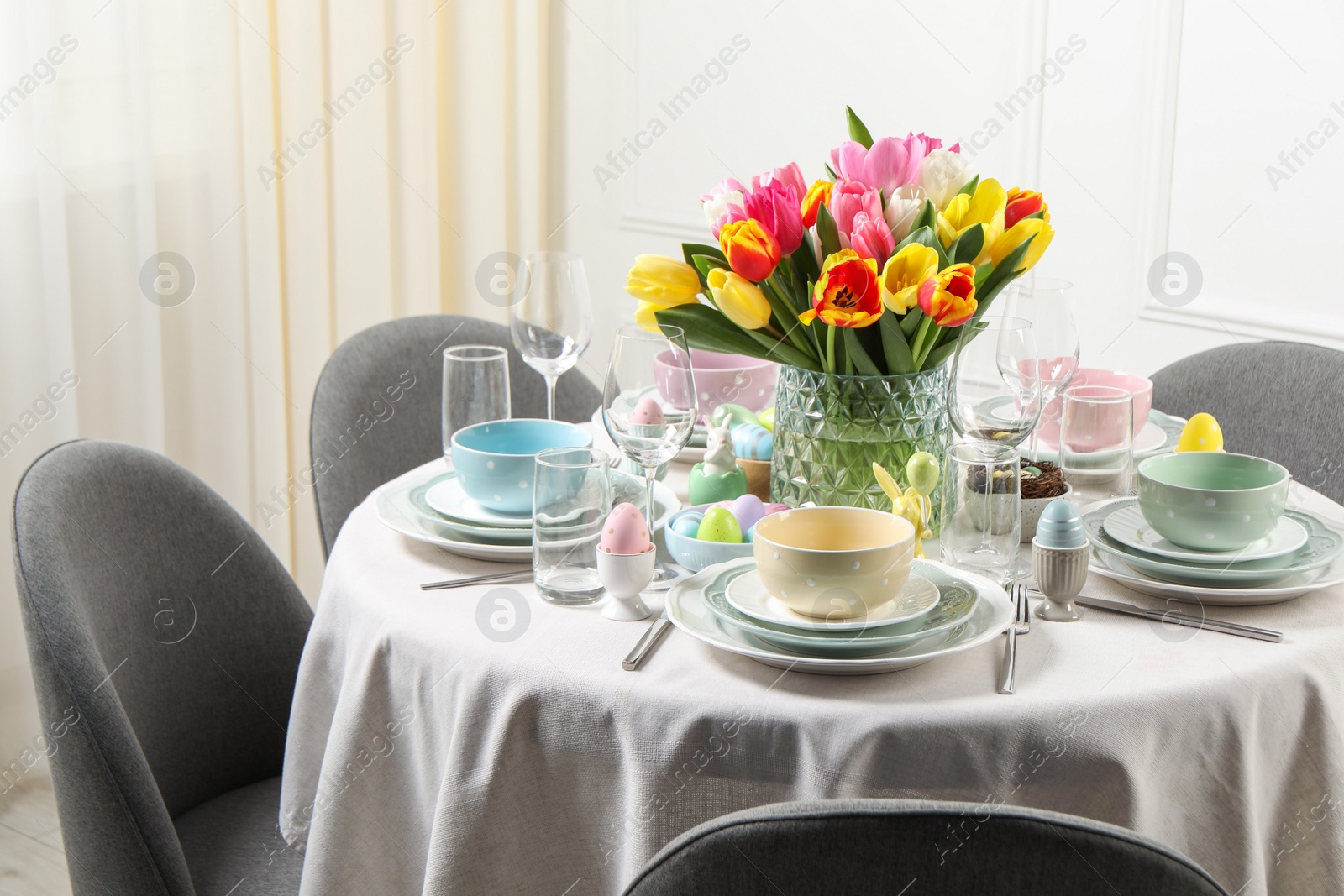 Photo of Easter celebration. Festive table setting with beautiful flowers and painted eggs