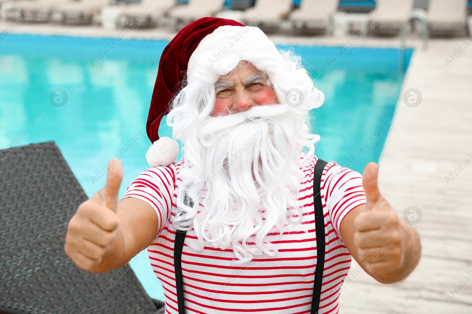 Photo of Authentic Santa Claus near swimming pool at resort