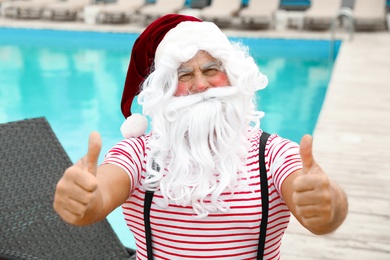 Photo of Authentic Santa Claus near swimming pool at resort