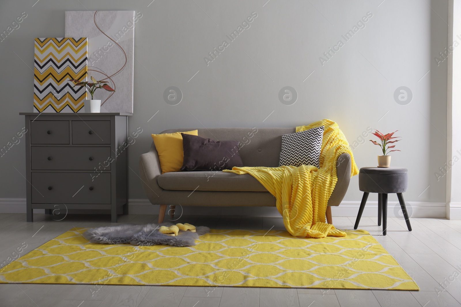 Photo of Comfortable sofa with pillows and plaid in living room. Interior design