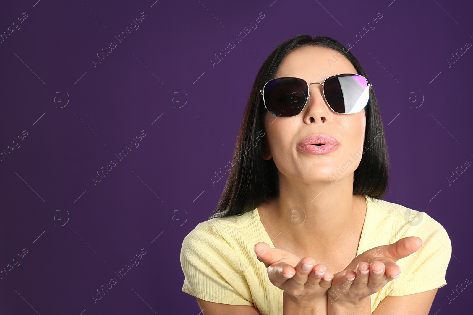 Photo of Beautiful woman wearing sunglasses on purple background. Space for text