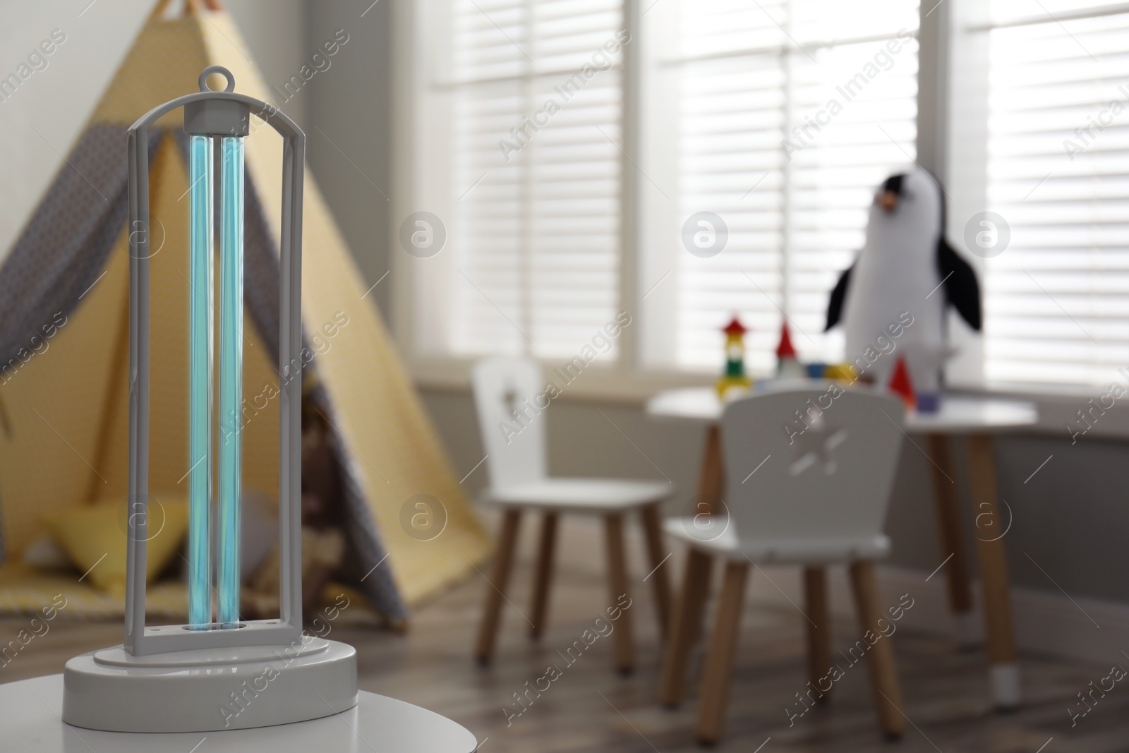 Photo of UV sterilizer lamp on table at home. Space for text