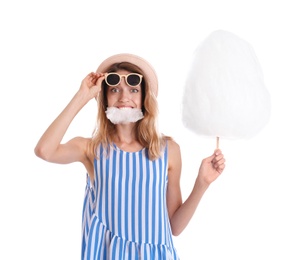 Photo of Happy young woman eating cotton candy on white background