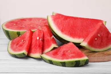 Juicy ripe cut watermelons on white wooden table, closeup