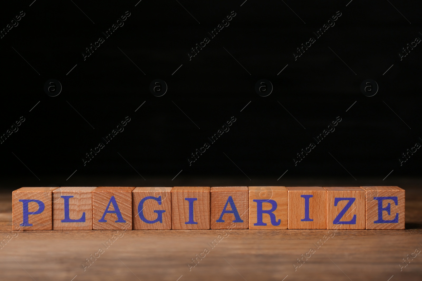 Photo of Wooden cubes with word Plagiarize on table, space for text