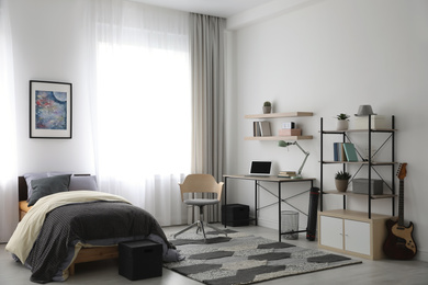 Modern teenager's room interior with workplace and bed