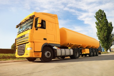 Photo of Modern yellow truck parked on country road