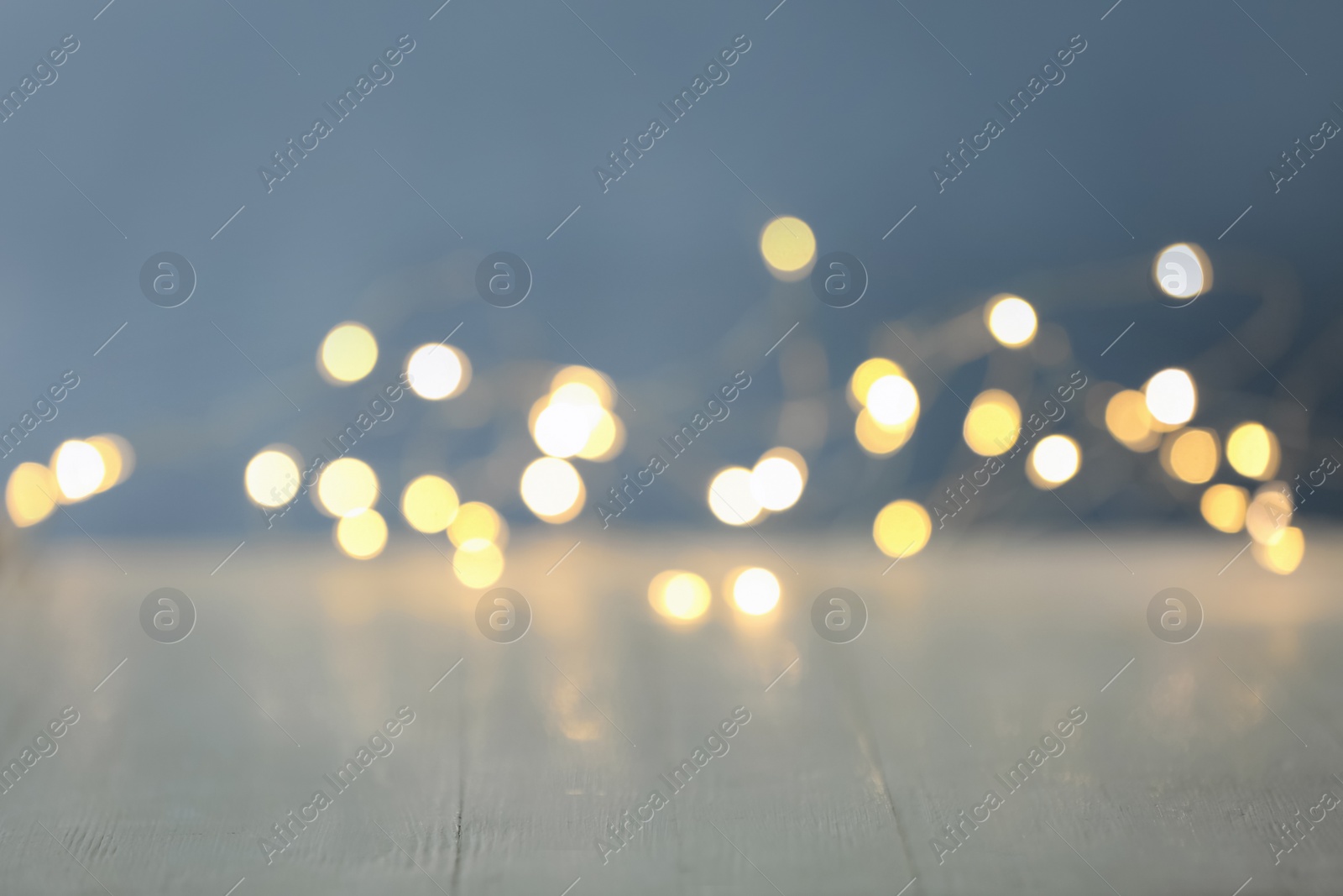 Photo of Blurred view of beautiful lights on light table, space for text