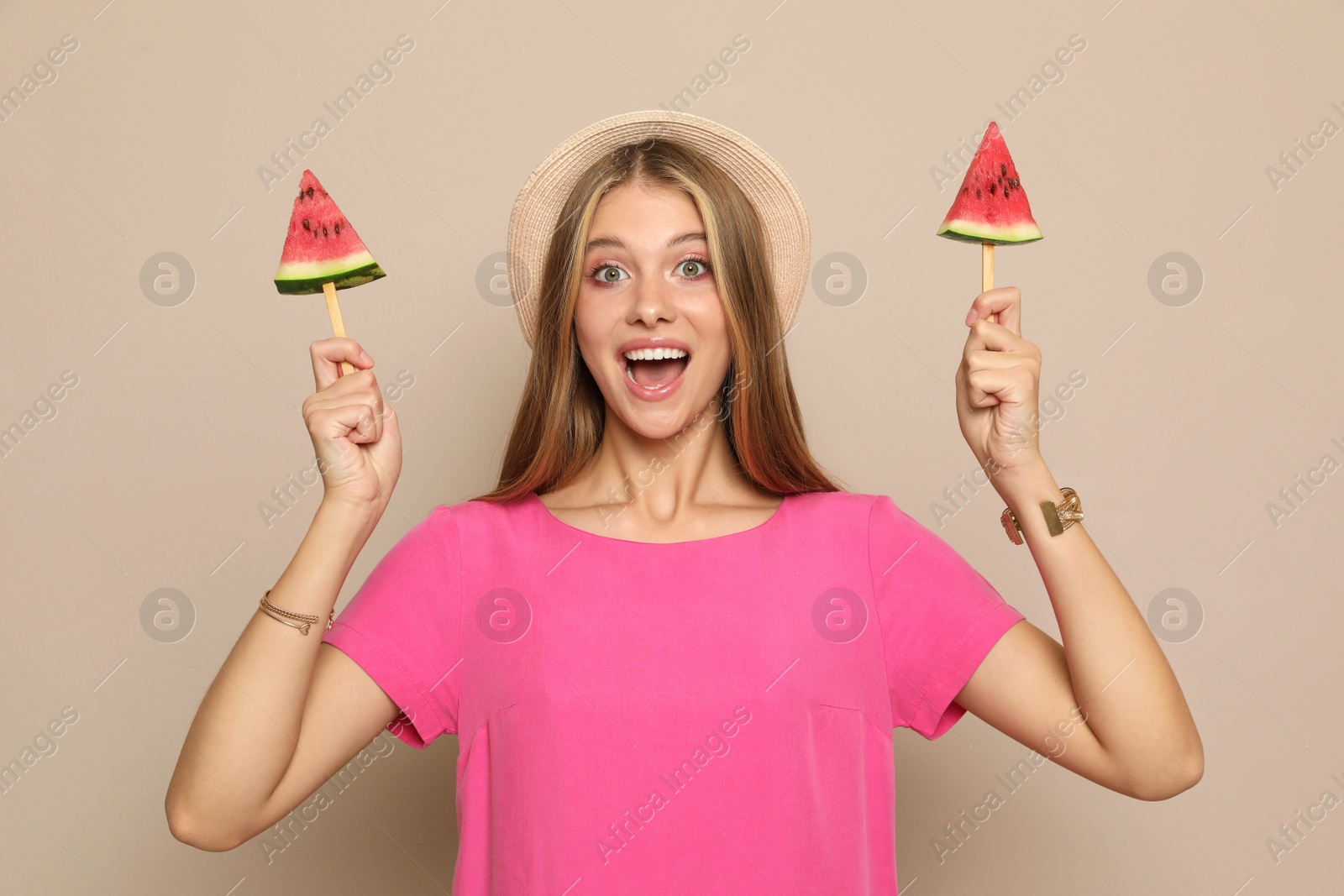 Photo of Beautiful girl with pieces of watermelon on beige background