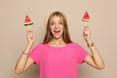 Beautiful girl with pieces of watermelon on beige background