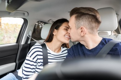 Photo of Happy young couple doing nose rub in car