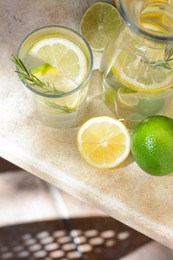 Photo of Tasty refreshing lemonade and ingredients on light table, above view. Space for text