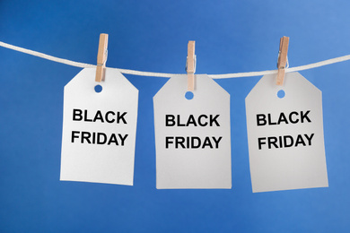 Blank tags hanging on blue background. Black Friday concept