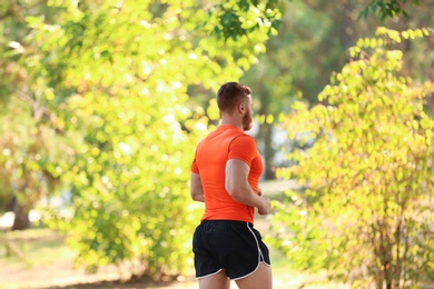 Young man running in park on sunny day