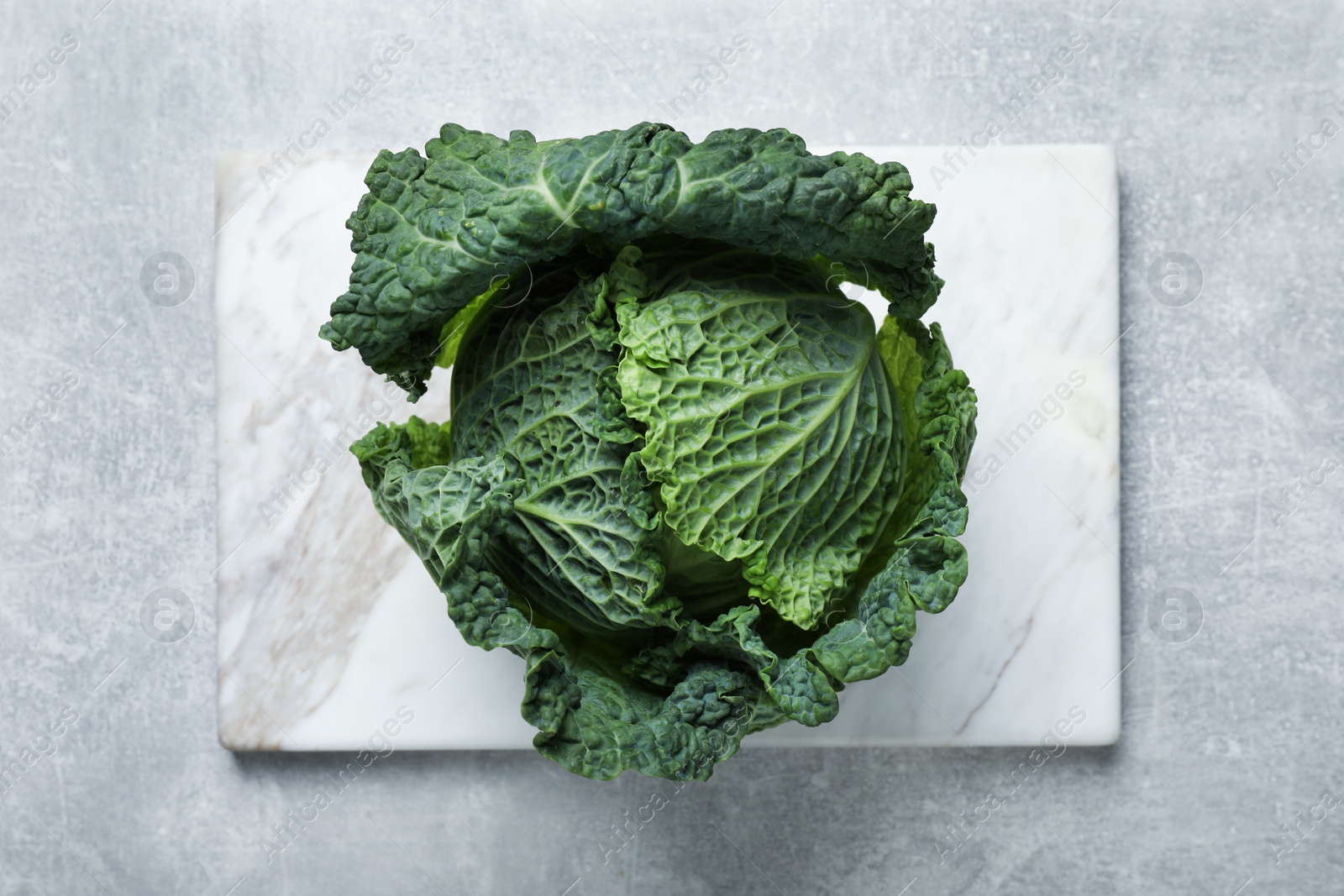Photo of Fresh ripe savoy cabbage on grey table, top view