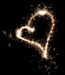 Bright sparkling heart contour on black background 