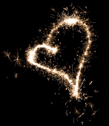 Image of Bright sparkling heart contour on black background 