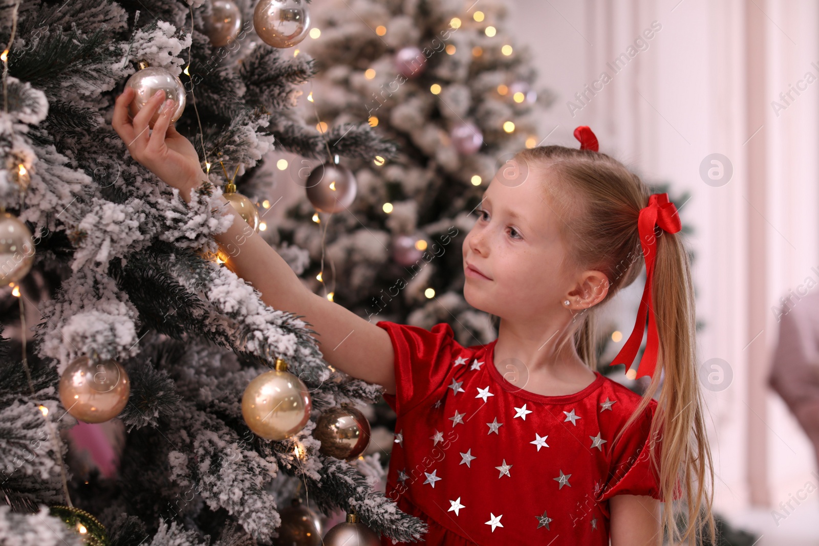 Photo of Cute little child near Christmas tree at home