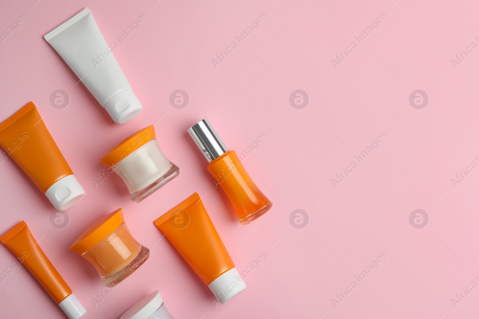 Photo of Set of luxury cosmetic products on pink background, flat lay. Space for text