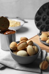 Photo of Delicious walnut shaped cookies with condensed milk on white wooden table
