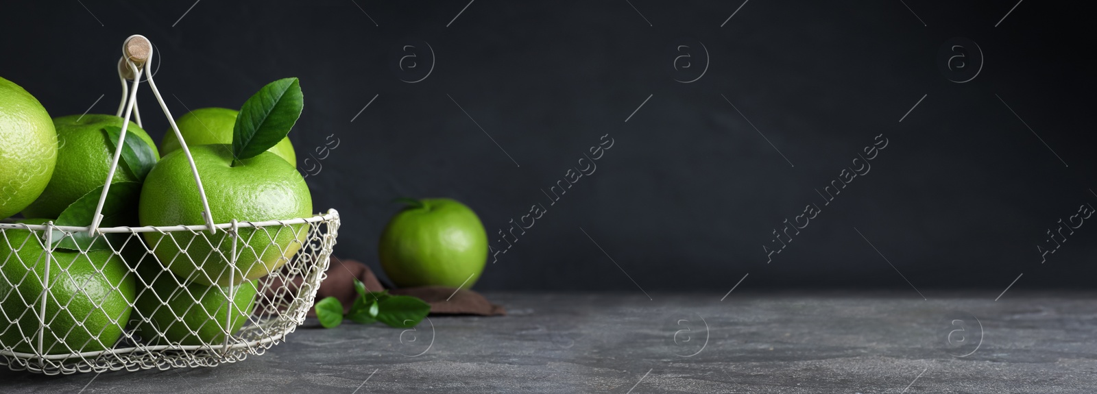 Image of Fresh ripe sweeties in metal basket on grey table, space for text. Banner design