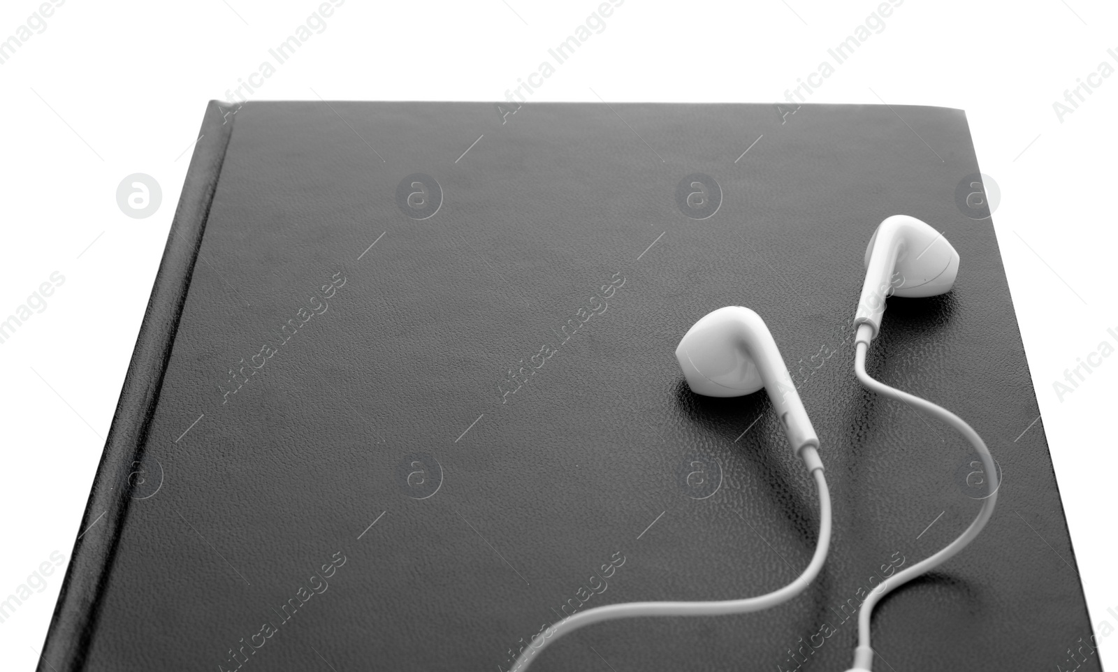 Photo of Bible and earphones on white background, closeup. Religious audiobook