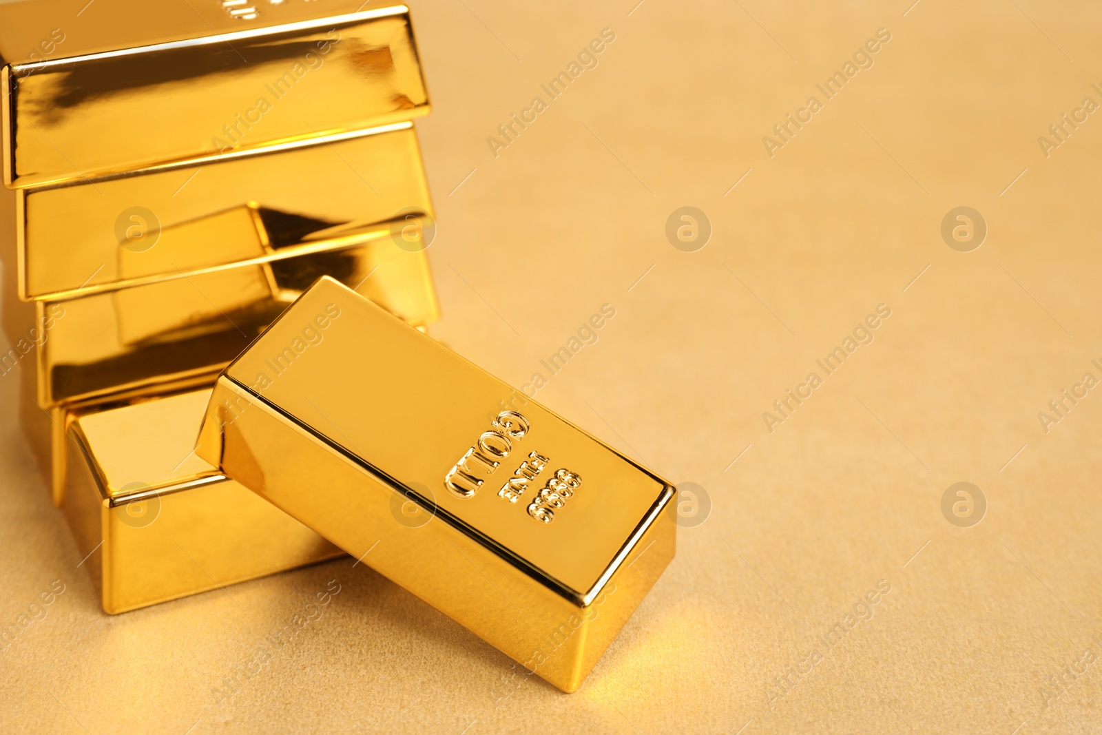 Photo of Many shiny gold bars on color background. Space for text