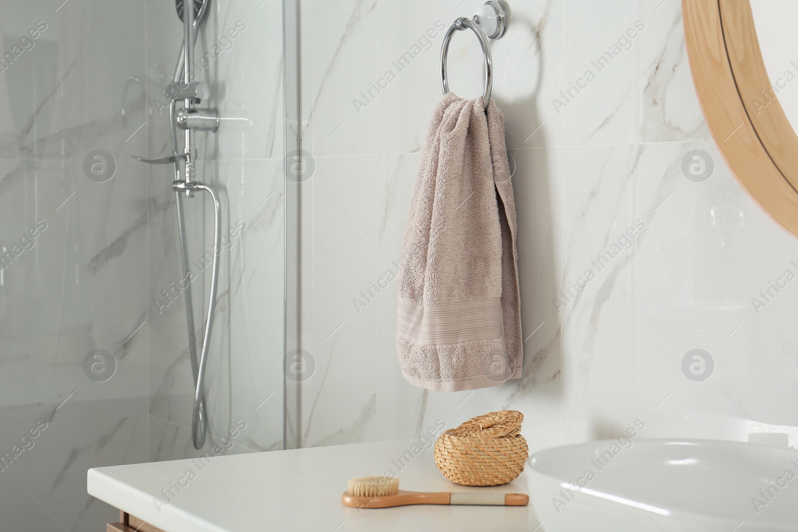 Photo of Soft towel on wall above bathroom countertop with toiletries