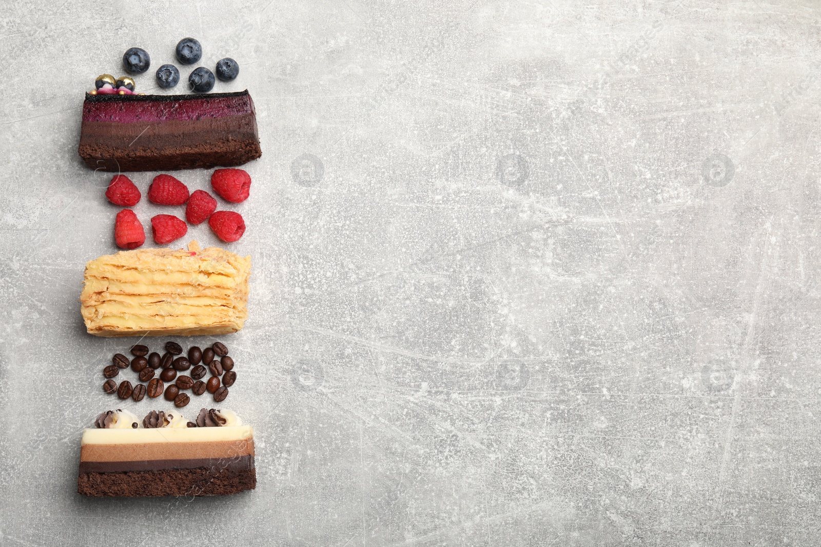 Photo of Different tasty cakes on light grey table, flat lay. Space for text