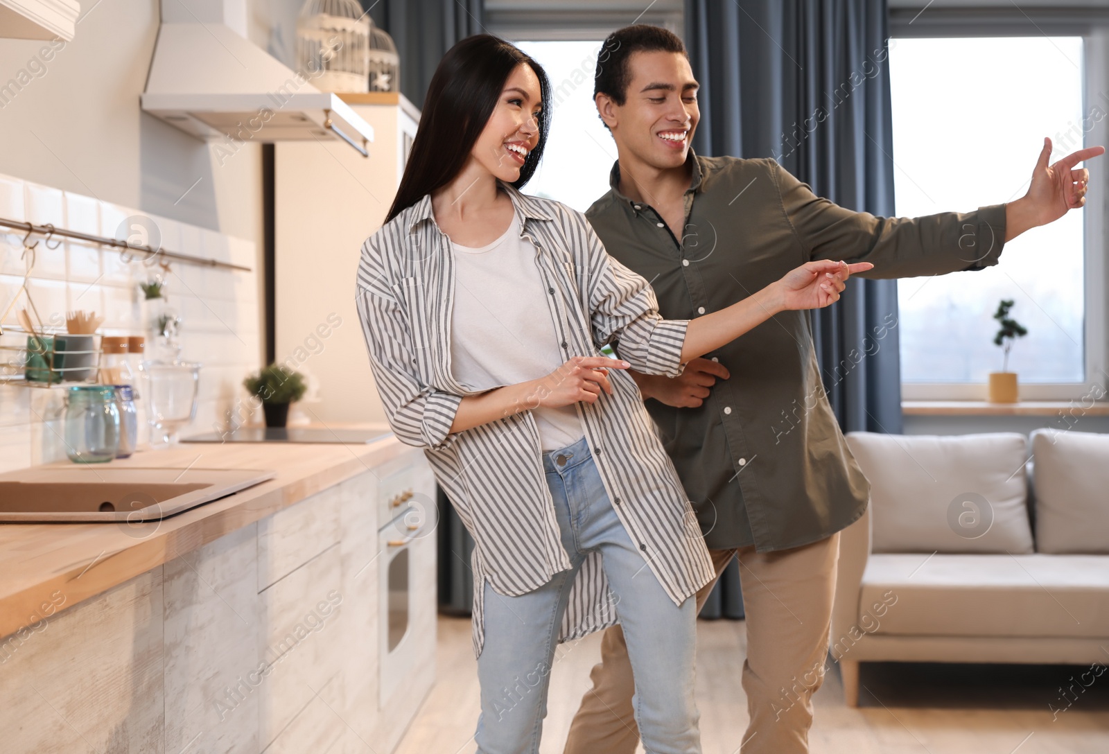 Photo of Lovely young interracial couple dancing at home