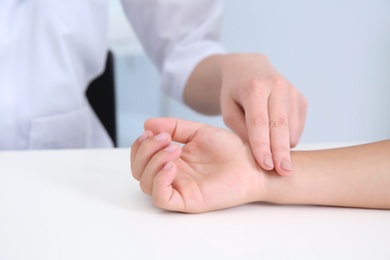 Doctor checking little boy's pulse in hospital