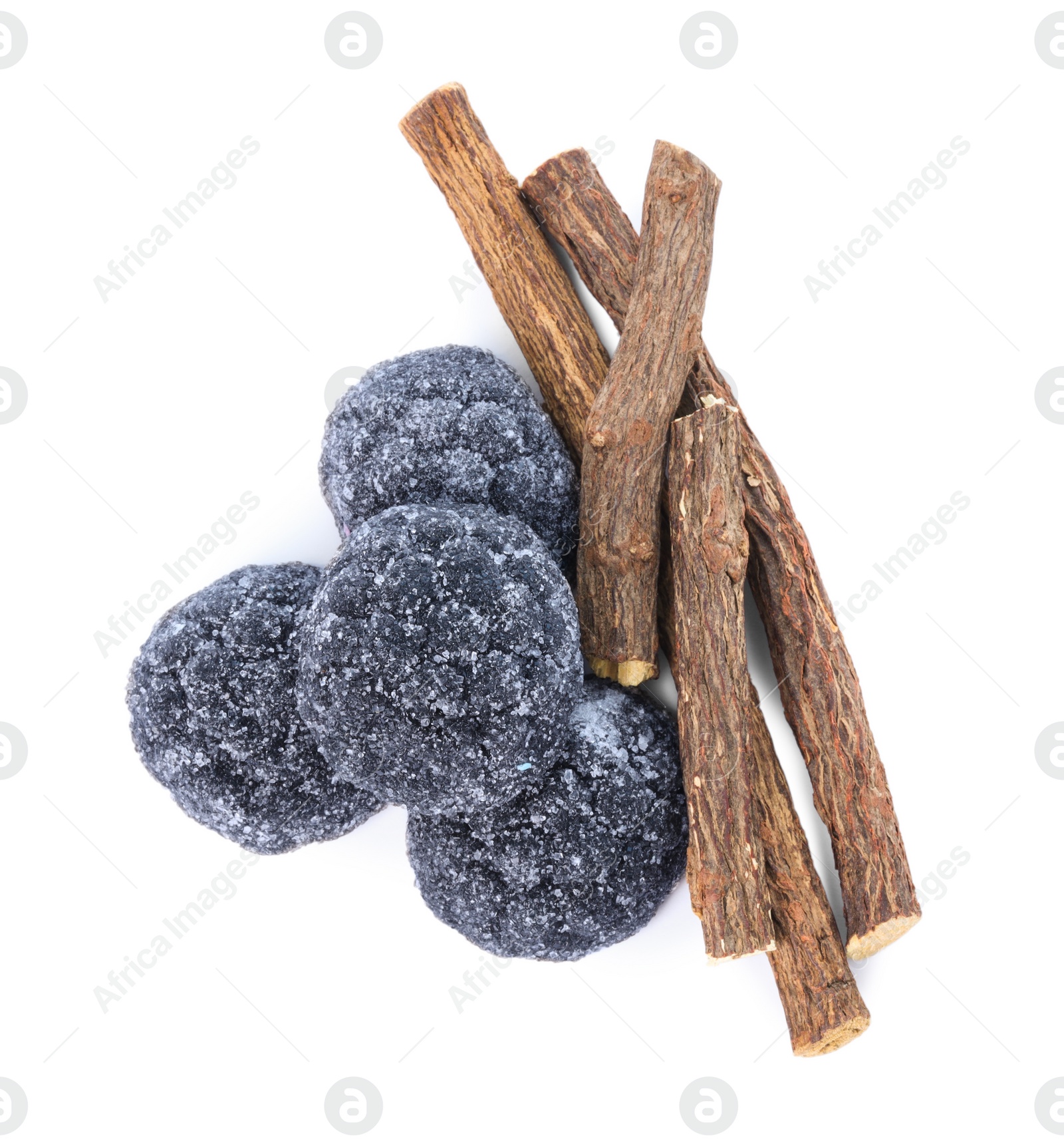 Photo of Many tasty candies and dried sticks of liquorice root isolated on white, top view