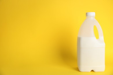 Photo of Gallon bottle of milk on yellow background. Space for text